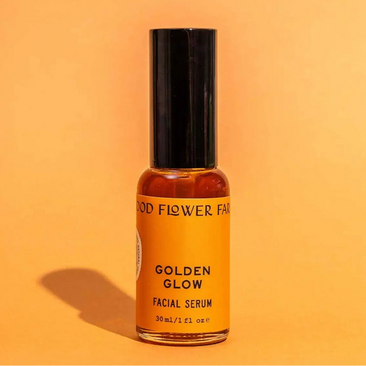 Facial serum bottle labeled 'Golden Glow' on an orange background