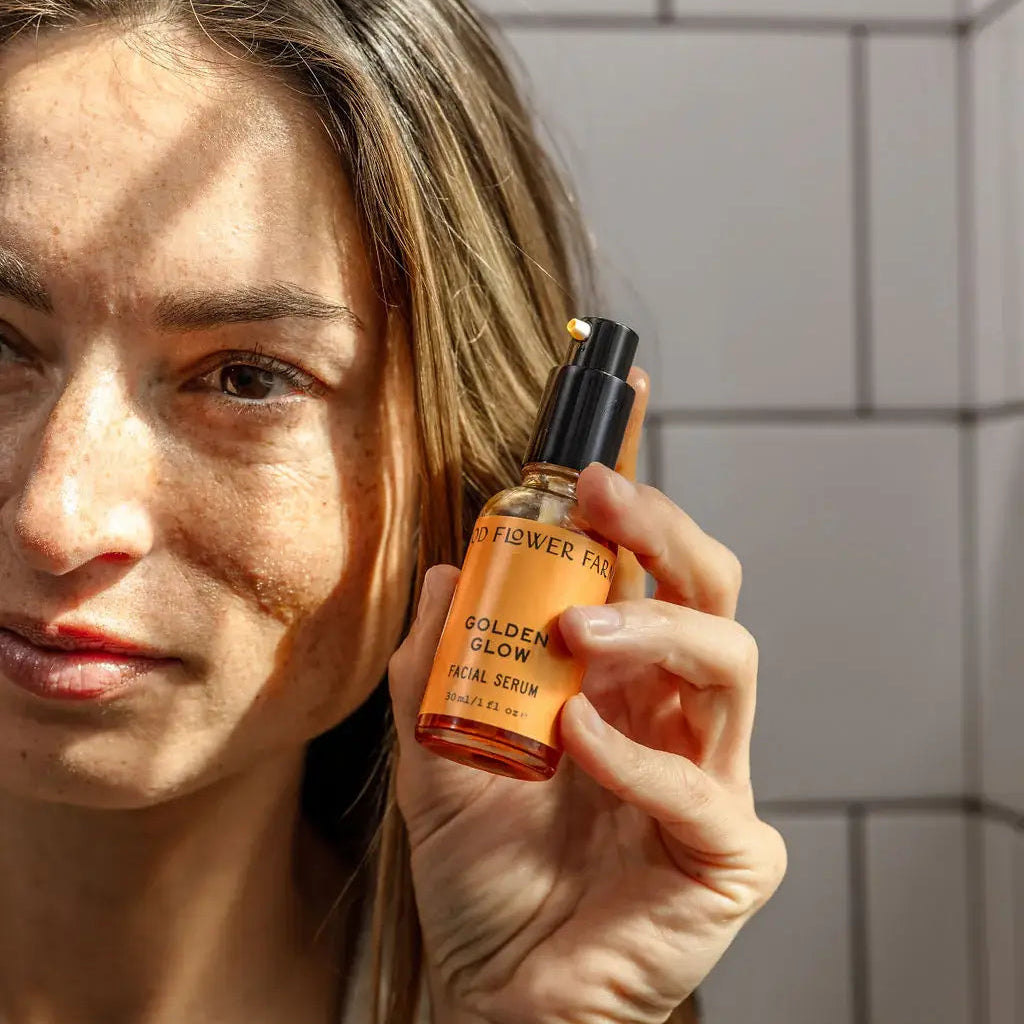 Woman holding a skincare product bottle with a neutral background